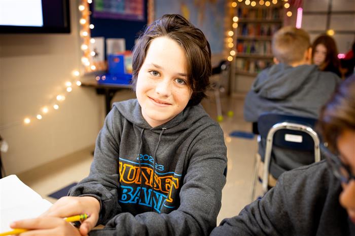 Student sitting at a desk smiling